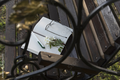 Diary, reading glasses, Jasmine flowers on the Park bench.