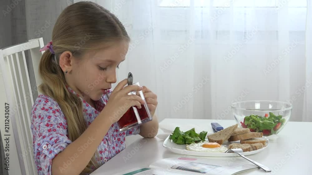 Child Eating Eggs with Green Salad Lettuce, Kid Drinking Tea, Girl in Kitchen Child Eating Eggs with Green Salad Lettuce, Kid Drinking Tea, Girl in Kitchen