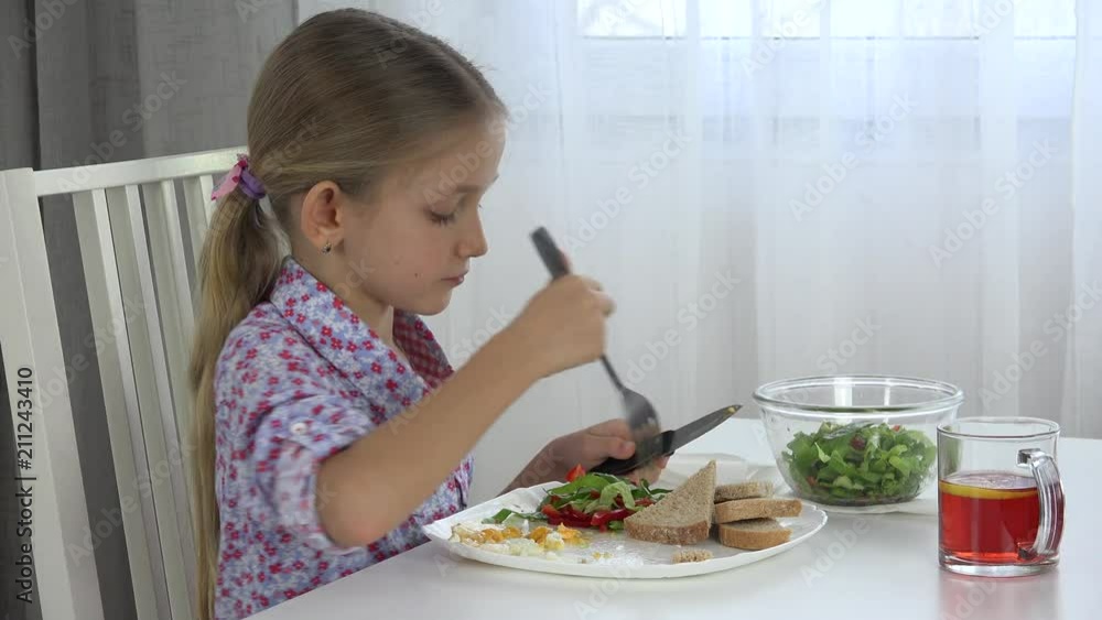 Child Eating Eggs with Green Salad Lettuce, Kid Drinking Tea, Girl in Kitchen Child Eating Eggs with Green Salad Lettuce, Kid Drinking Tea, Girl in Kitchen