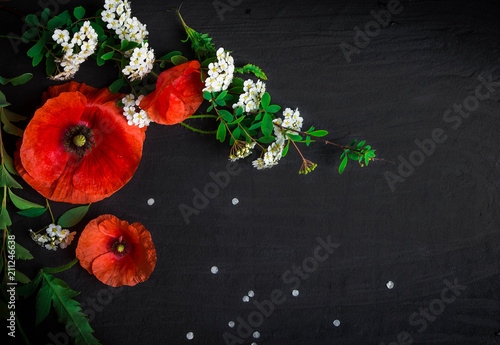 Bouquet of red poppies and white Spiraea on a black background. Wild flowers.
