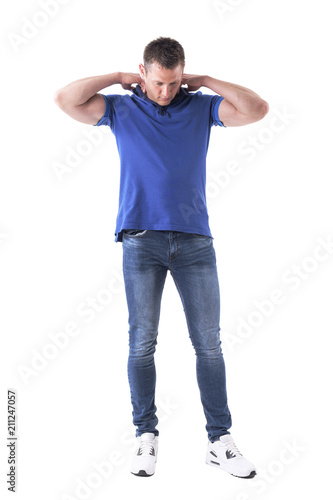 Young adult casual man put on blue polo shirt and looking down. Full body isolated on white background. 