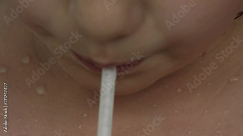 close-up child's lips drinking a milkshake through a straw. 4K photo