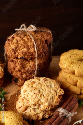 Christmas concept with cookies and decorations on a log over wooden background, selective focus