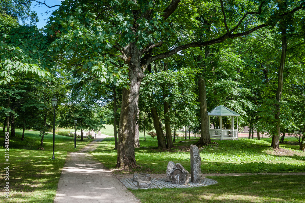 Stone pathway in the green park with white pavilion and street lighting. Park of Saka manor. Estonia. Baltic. Stone pathway in the green park with white pavilion and street lighting. Park of Saka manor. Estonia. Baltic.