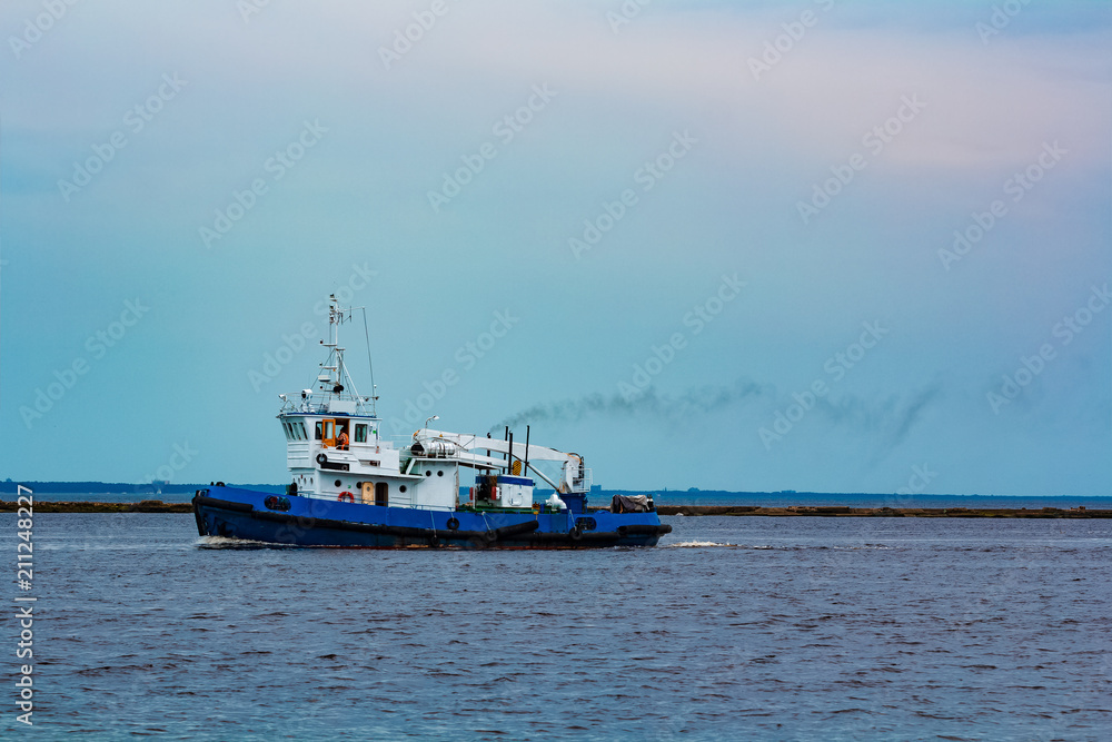 Blue tug ship underway