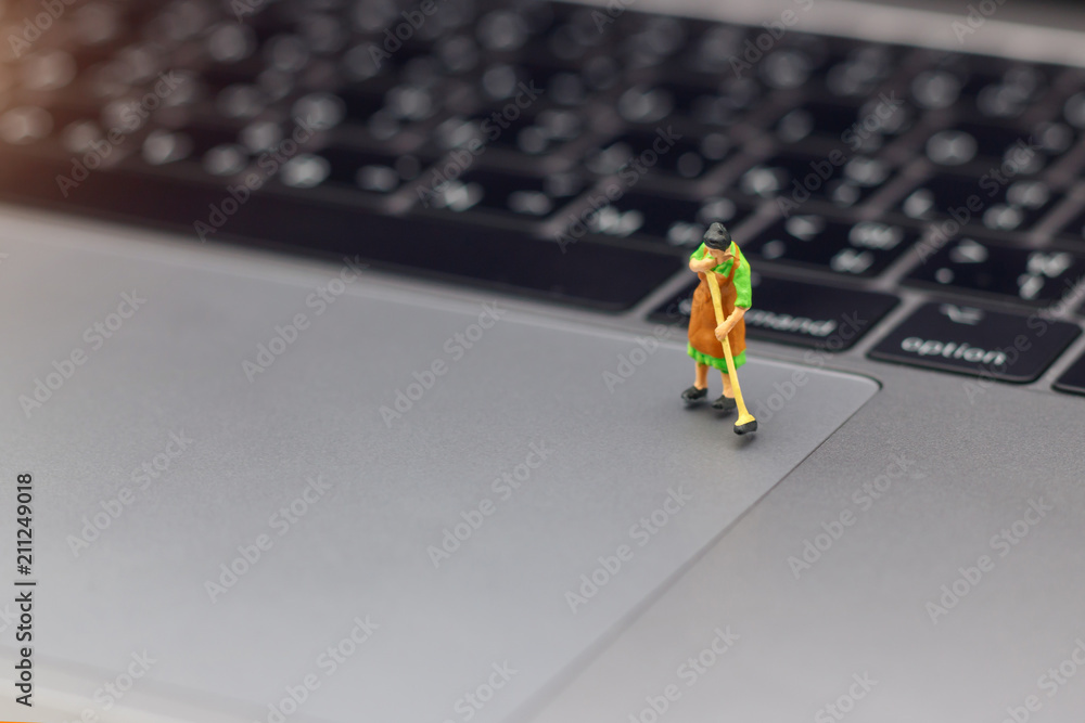 Miniature women cleaning pointing device laptop. Concept of cleaning viruses computer, security and technology . Miniature women cleaning pointing device laptop. Concept of cleaning viruses computer, security and technology .
