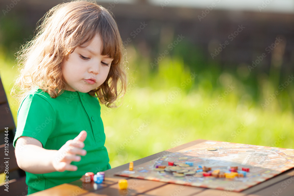 Moscow, june 17 2018. Adorable little girl playing board games alone