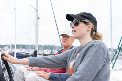 Daughter driving a motor cruiser out to sea with her father