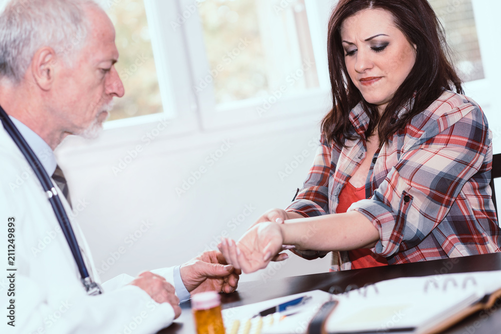 Doctor examining wrist of a female patient Doctor examining wrist of a female patient