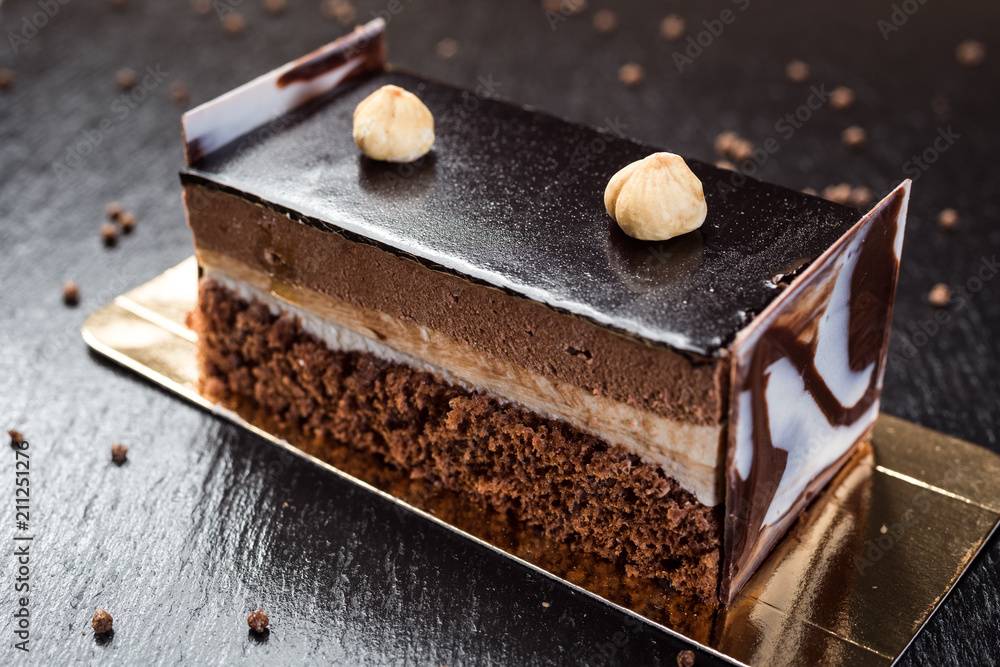 Dark chocolate vegan cake with candies and nuts on wooden background Dark chocolate vegan cake with candies and nuts on wooden background