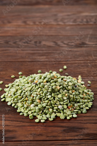 Pile of green peas on rustic wooden background  close-up  top view  selective focus.