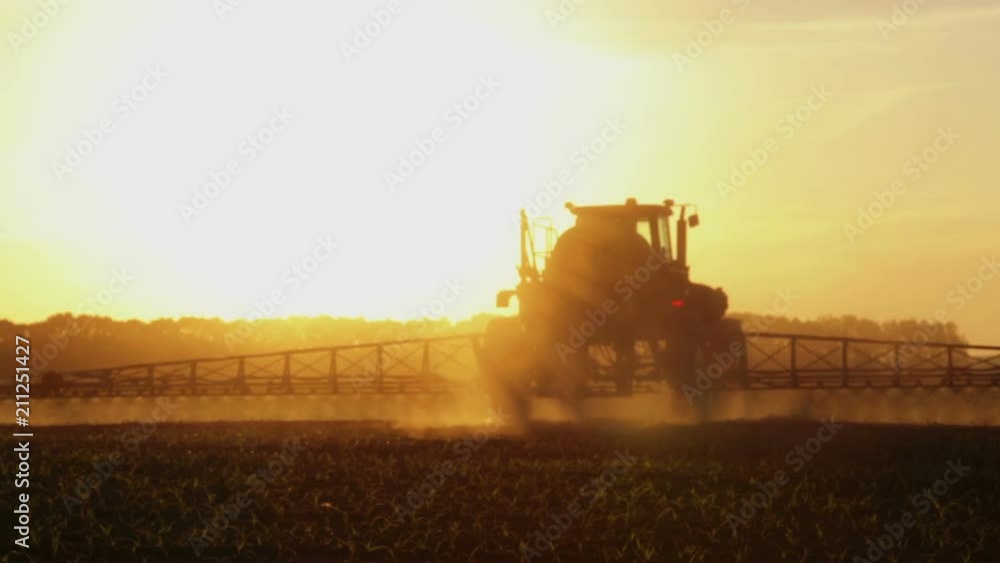 Tractor spraying chemicals in a field at sunset. Fertilizer application in the field of corn at sunset of the day.
Tractor spraying chemicals in a field at sunset. Fertilizer application in the field of corn at sunset of the day.