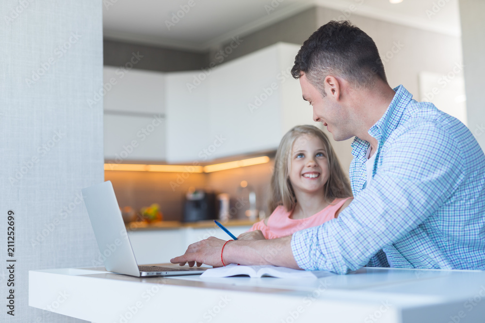 Smiling father with a daughter doing homework Smiling father with a daughter doing homework