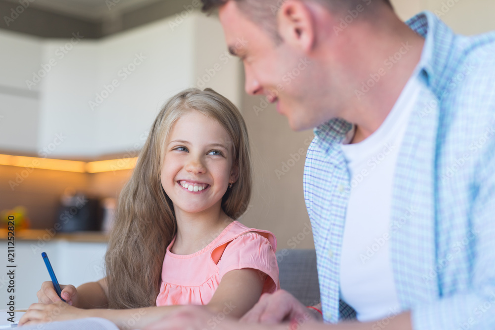 Smiling father with a little daughter doing homework Smiling father with a little daughter doing homework