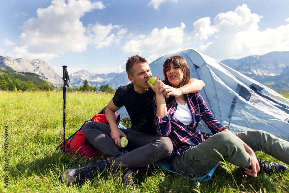 Couple enjoying at camping.Hikers eating apple at mountain near the tent Couple enjoying at camping.Hikers eating apple at mountain near the tent