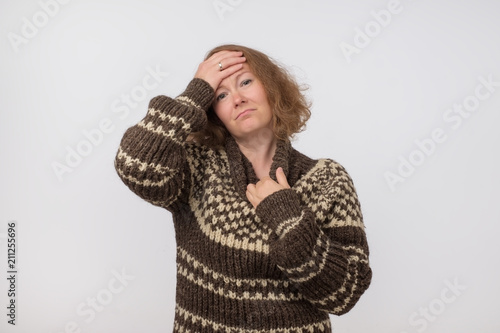 Portrait of sick ill european female dressed in big wool brown sweater. Woman suffering from physical discomfort photo