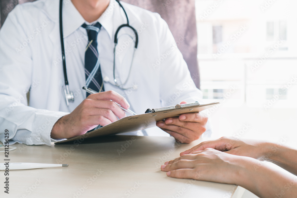 Close up hands of doctor taking note patient history to clipboard and giving diagnosis her disease. Close up hands of doctor taking note patient history to clipboard and giving diagnosis her disease.