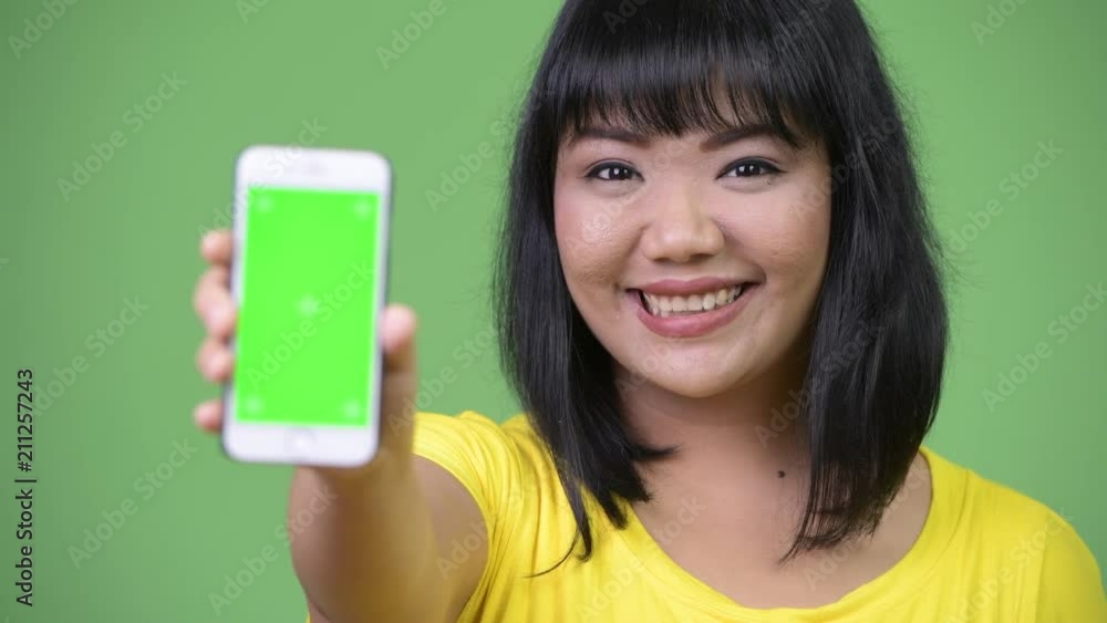 Beautiful happy Asian woman showing phone Beautiful happy Asian woman showing phone