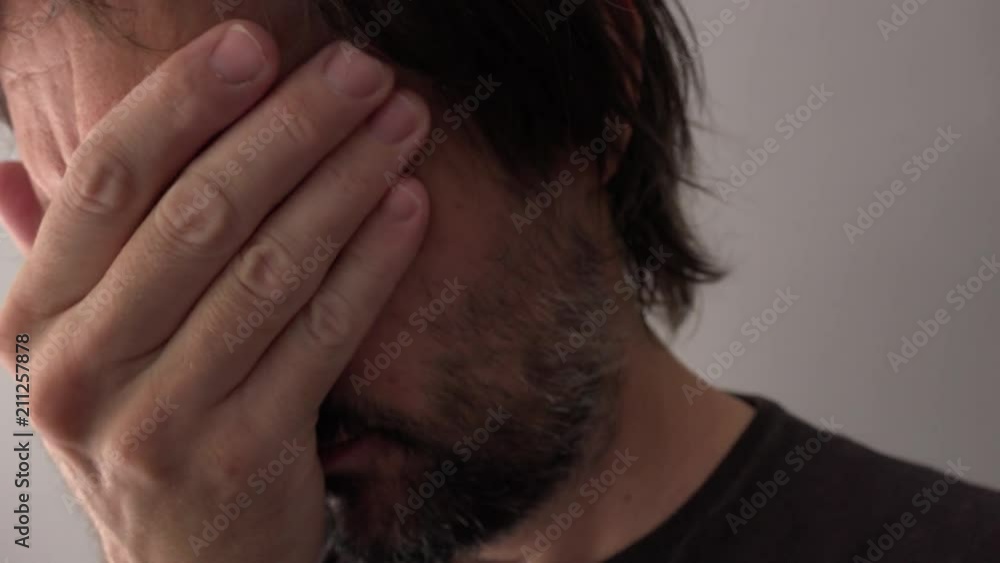 Sad man crying and covering face, close up of face Sad man crying and covering face, close up of face