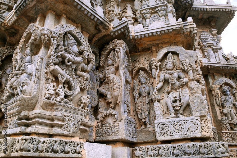 Ornate wall panel reliefs depicting from left dancing Shiva, Krishna as Kaliya-mardana and a deity and dancing Parvati, Kedareshwara temple, Halebidu, Karnataka