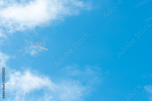 Airplane on blue sky and white clouds. Commercial airline flying on blue sky. Travel flight for vacation. Aviation transport. Travel on vacation by plane.