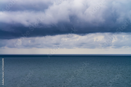 Fototapeta Naklejka Na Ścianę i Meble -  dense rain clouds and a tornado over the sea