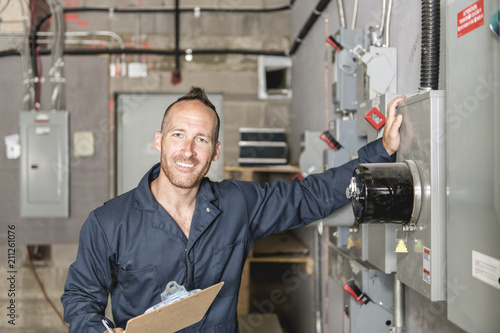 Man Technician servicing at work on electric room