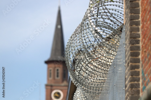 Prikkeldraad met op de achtergrond een kerk photo