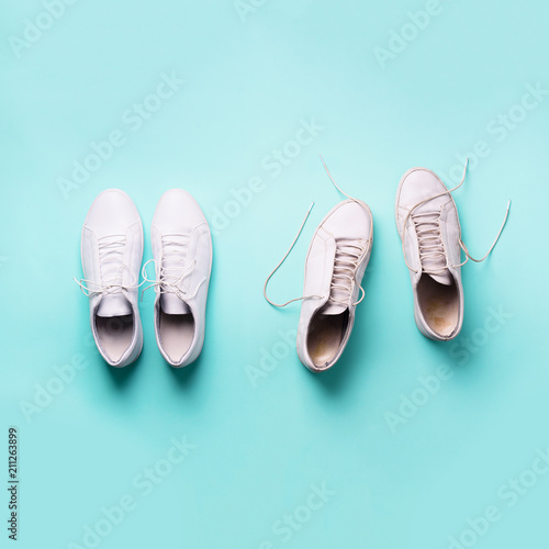 Old dirty sneakers vs new white sneakers on blue background. Trendy footwear. Square crop. Top view. Concept of experience, discipline and chaos, accuracy \ mess, stylish shoes. Back to school