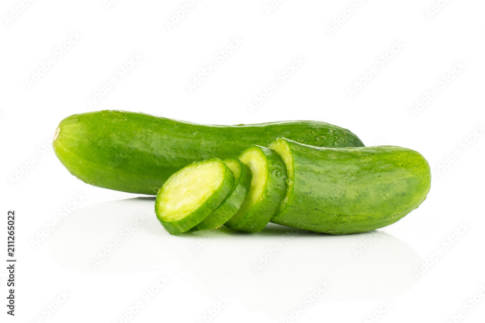 One fresh green mini cucumber with a sliced half and three slices isolated on white background. One fresh green mini cucumber with a sliced half and three slices isolated on white background.