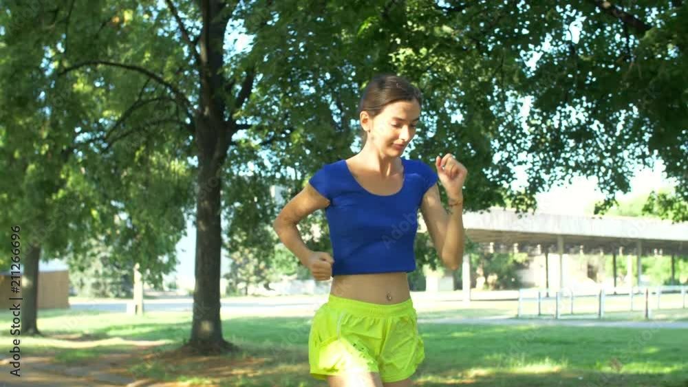 Beautiful fit female runner touching foot in pain, has sprained and