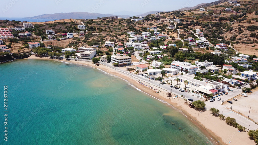 Aerial drone bird's eye view of picturesque village of Batsi with traditional taverns and clear water beach, Andros island, Cyclades, Greece