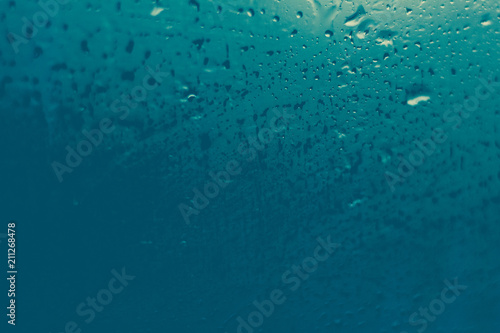 misted glass. Water on the car glass. beautiful desktop, blue, background.