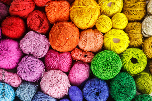 Fototapeta Rainbow-colored yarn balls, viewed from above.