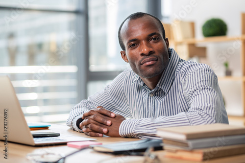 Concentrated dark-skinned man being at work