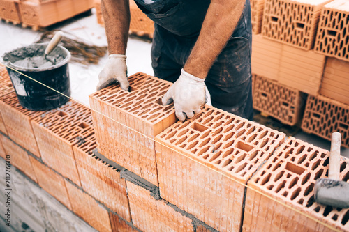 Foto Industrial worker, bricklayer using tools and bricks for building house