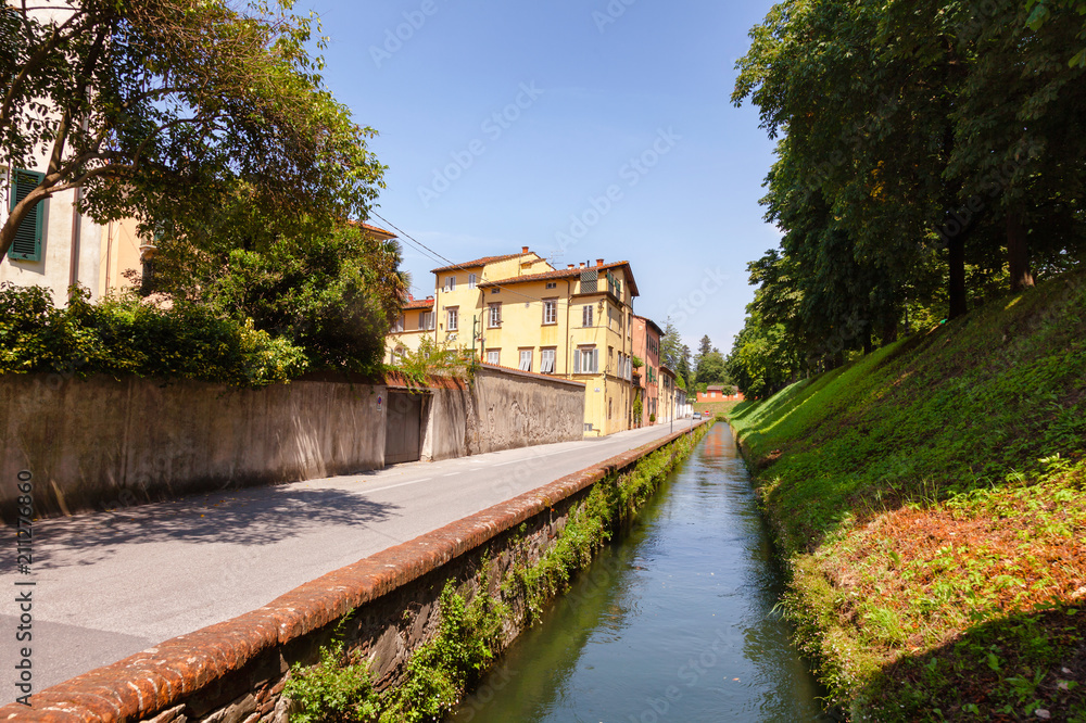 Lucca old town cityscape with canal along fortified city wall Tuscany Italy