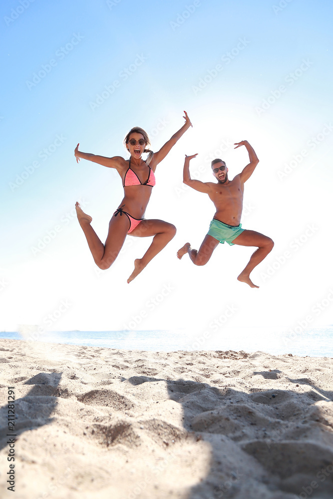 Happy couple jumping on beach. Happy couple jumping on beach.