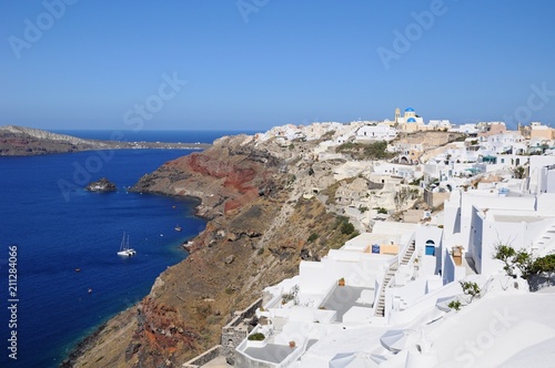 Fototapeta Naklejka Na Ścianę i Meble -  Famous stunning view of white architectures and colors above the volcanic caldera in the village of Oia in Santorini island, Greece
