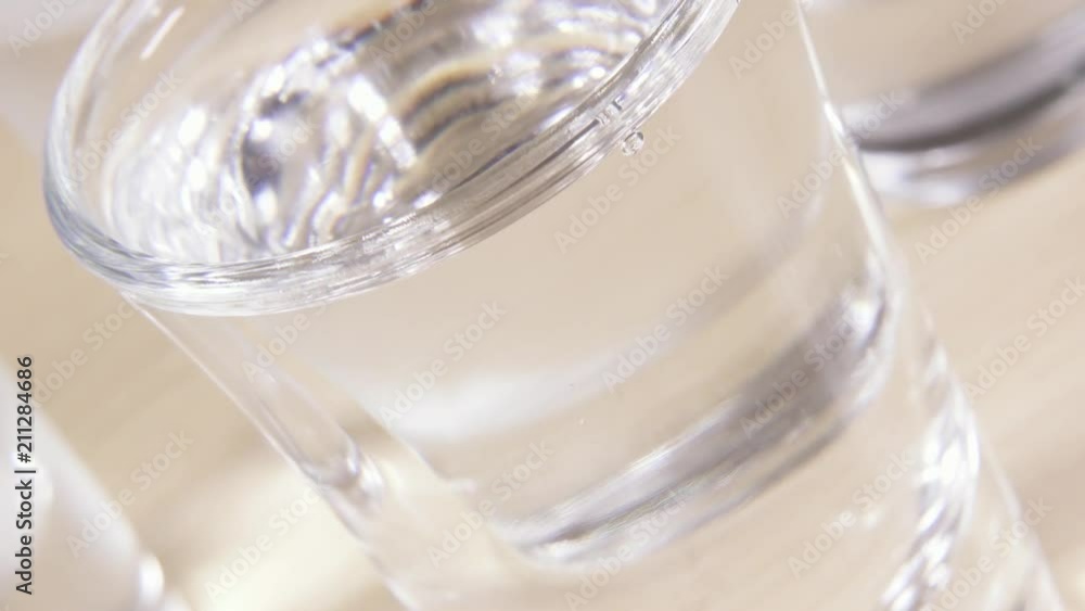 Vodka is poured into a glass and the camera is tilted Vodka is poured into a glass and the camera is tilted