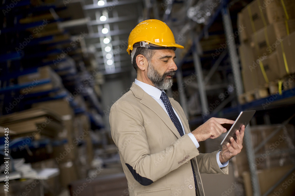 Middle-aged businessman with digital tablet in factory Middle-aged businessman with digital tablet in factory
