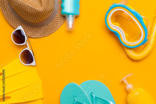 Composition of beachwear and accessories on a yellow background