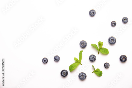 Bunch of fresh organic blueberry berries and mint leaves in seamless pattern, white background. Clean eating concept. Healthy nutritious vegan snack, raw diet. Close up, copy space, top view, flat lay