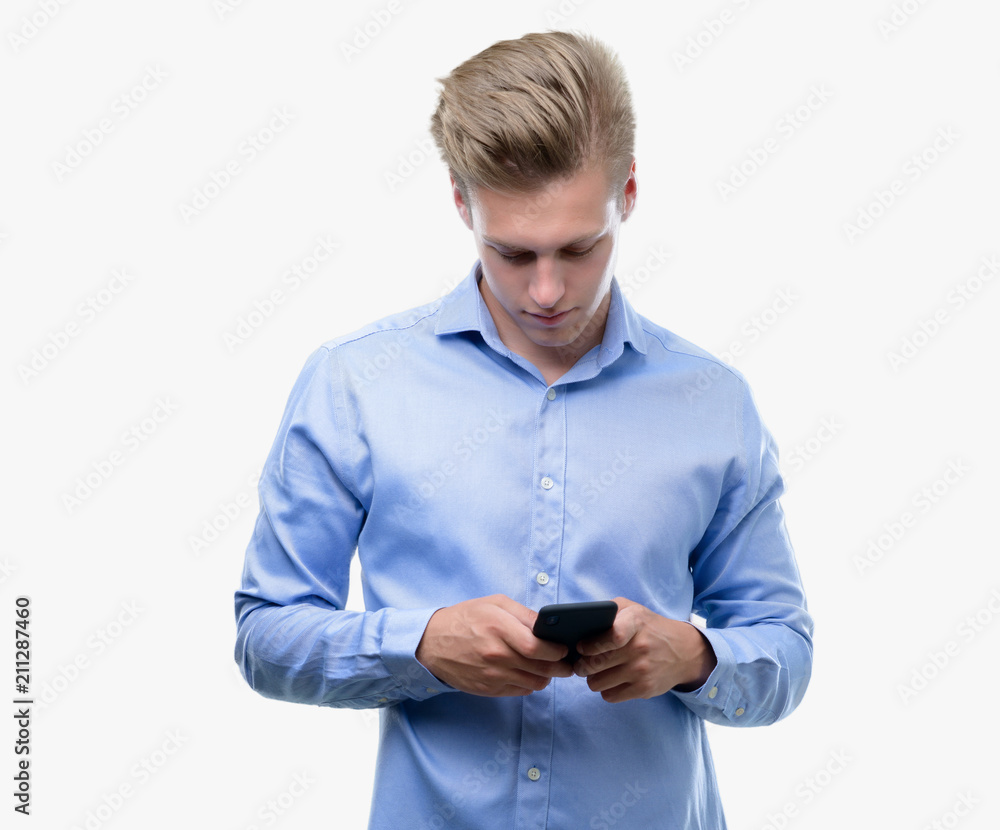 Young handsome blond man using smartphone with a confident expression on smart face thinking serious Young handsome blond man using smartphone with a confident expression on smart face thinking serious