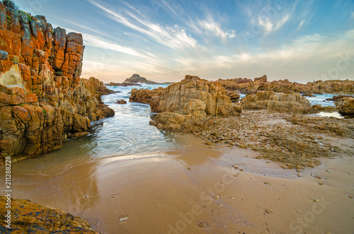 Knysna heads coast rocks, Indian Ocean waves through the rocks at sunset, Garden Route, South Africa photo