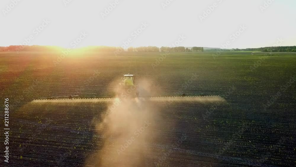 Shooting from a drone sprayer in a field at sunset. Top view of the operating tractor sprayer in the field on the farm.
Shooting from a drone sprayer in a field at sunset. Top view of the operating tractor sprayer in the field on the farm.