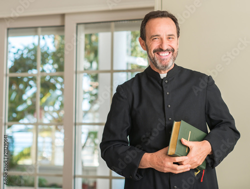 Fotografiet Christian priest man with a happy face standing and smiling with a confident smi