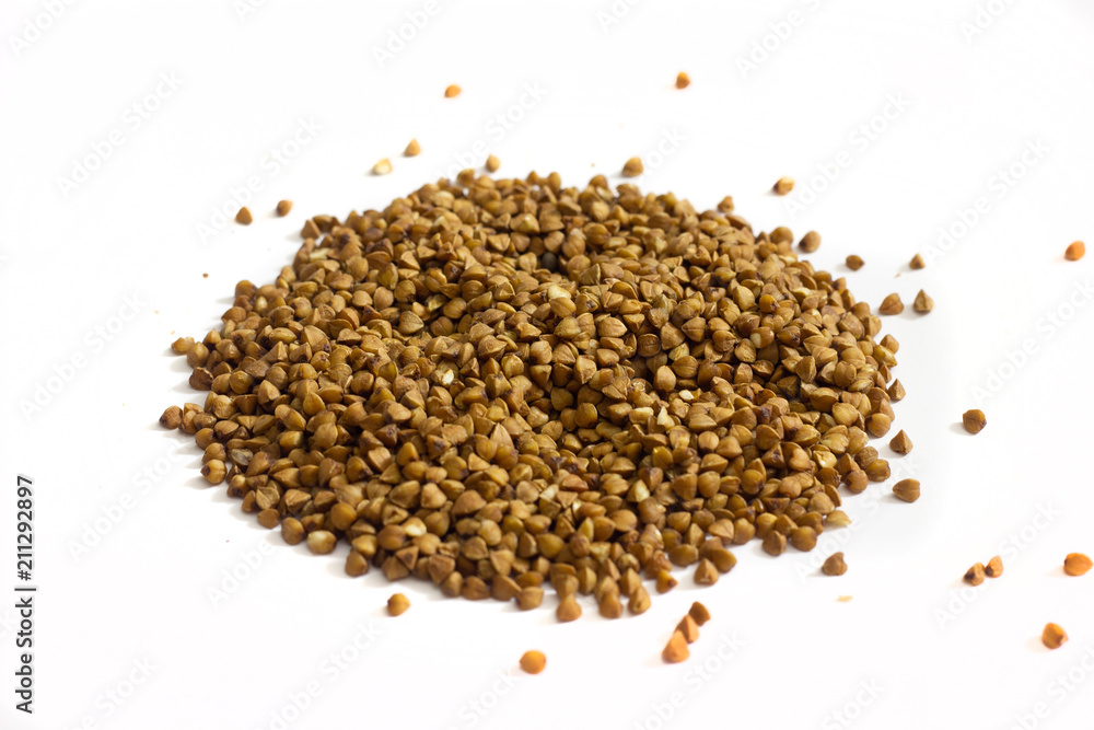 Buckwheat groats scattered on a white background Buckwheat groats scattered on a white background