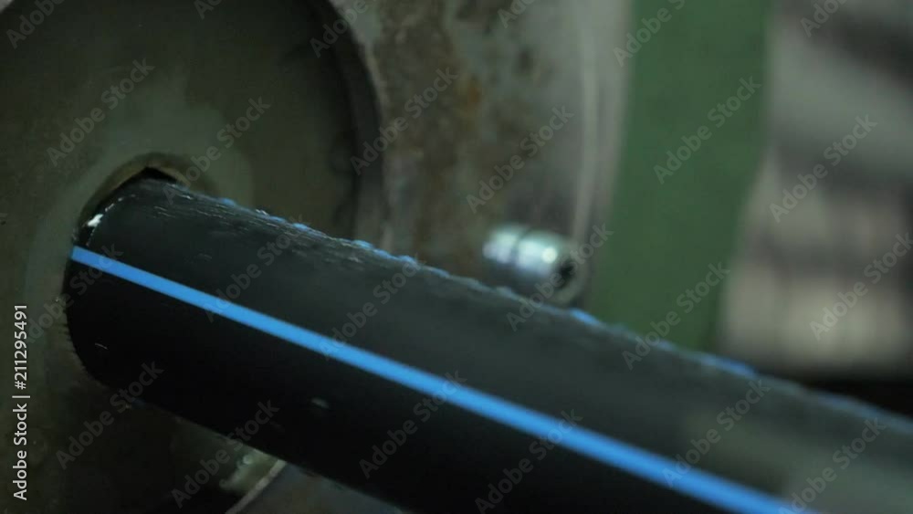Pipes manufacturing production line. Manufacture of plastic water pipes of the factory. Process of making plastic tubes on the machine tool with the use of water and air pressure. Pipes manufacturing production line. Manufacture of plastic water pipes of the factory. Process of making plastic tubes on the machine tool with the use of water and air pressure.