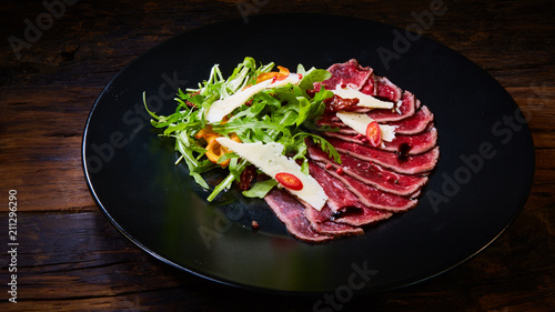 Barbecue wagyu roast beef sliced as top view on a metal tray with copy space right photo